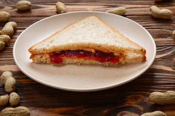 Peanut butter and jelly sandwich on wooden background. Space for text or design.