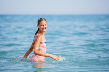 Fototapeta na wymiar Girl in swimsuit having fun on tropical beach