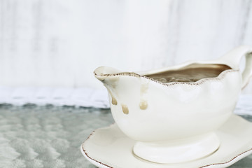 Messy gravy boat with drips of gravy running down the side ready for Thanksgiving Day. Extreme...