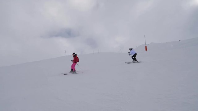 Two Woman Skiers Skiing On The Difficulty Mountain Downhill In Heavy Fog