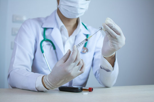 Doctor holding medical injection syringe and stethoscope