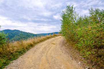 Fototapeta na wymiar Unpaved rural road on a high mountain peak in Transylvania region of Romania