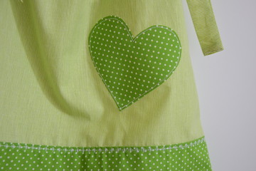 Mädchenkleid mit grünem Stoff, Ziernähten und Herz als Applikation, Handarbeit 