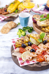 Vegetables, fruits and shrimp on the grill, for a summer lunch. Healthy food. Appetizers on a white background. Copy space
