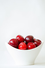 Cherries isolated. Cherries are in the white bowl on white background.