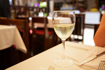 The glass of white wine in street cafe. Space for text
