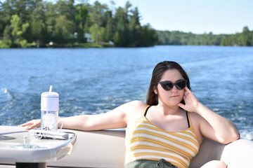 Obraz premium Young Woman Relaxing on a Pontoon Ride