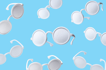 White sunglasses pattern on pastel blue background. Minimal summer concept. Flat lay.