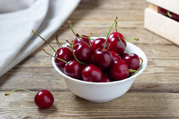 Cherries in the bowl on wooden table