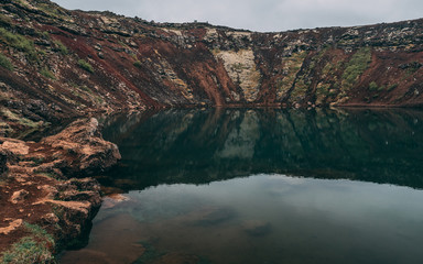 crater lake in iceland with reflection in the water