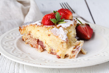 Cut of fresh pie with strawberry on wooden table