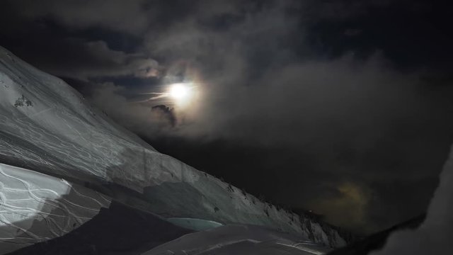 Night time laps up in the mountains. Overlooking the slopes of a ski area in the moonlight.