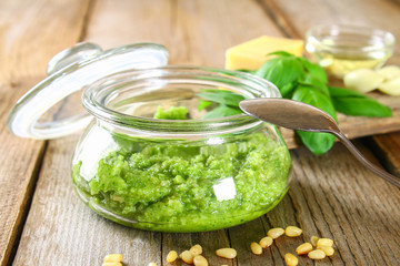 Homemade pesto sauce. Ingredients. Cheese, garlic, basil, pine nuts, olive oil on an old wooden table.