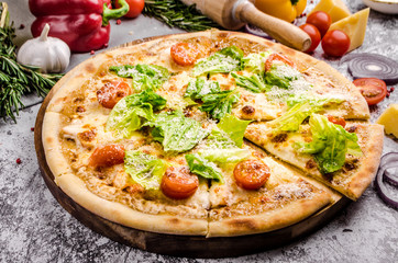 Homemade Vegan pizza with fresh vegetables and pesto, gray stone background, copy space, restaurant menu concept. Italian food style, close up.
