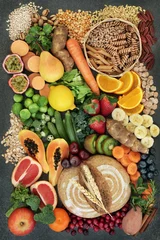 Zelfklevend Fotobehang High fibre health food concept with fresh whole grain rye bread, cereals, grains, fruit, vegetables, nuts, legumes, herbs and spices. Foods high in omega 3, antioxidants, anthocyanins and vitamins.  © marilyn barbone