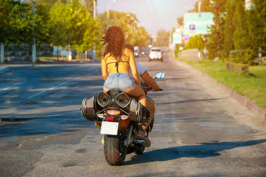 Woman In Shorts Riding A Motorcycle View From The Rear