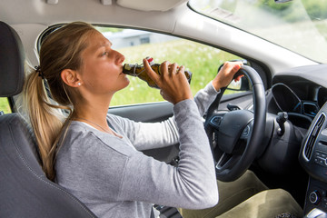 Frau trinkt Alkohol am Steuer ihres Autos