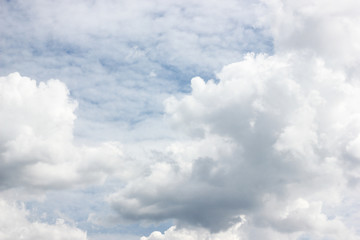 Bright white cumulus and cirrocumulus clouds on blue sky. Summer sunny cloudscape