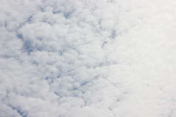 White cirrocumulus clouds on blue sky. Horizontal background of sunny summer cloudscape