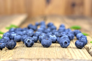 Healthy food,agriculture,harvest and fruit concept: ripe and fresh blueberries on an old wooden table.