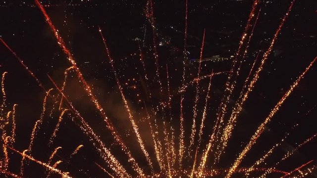 Bright firework explosion in the night sky. Fireworks salute with the black sky background. New years fireworks. Celebrating the Independence Day. Colorful burst of fireworks.