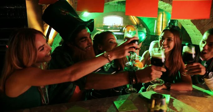 Multi-ethnic friends and couples celebrating Saint Patrick's day at pub