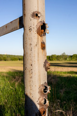 Holes from gunshots on a metal pipe
