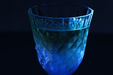 Close up transparency apple juice in crystal glass on black background