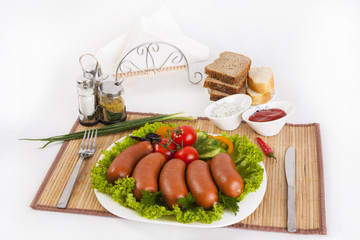 Boiled sausages with tomatoes, cucumbers and greens. Served with black or white bread.