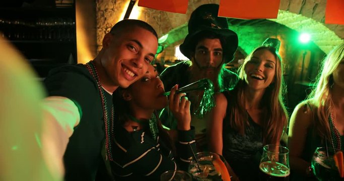 Young multi-ethnic friends taking selfies at Saint Patrick's day party