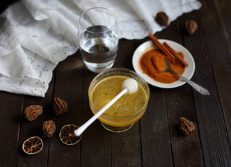 honey and cinnamon on dark wooden background
