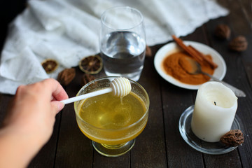 honey and cinnamon on dark wooden background
