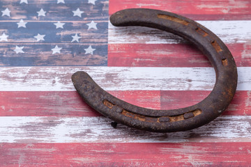 Old rusty horseshoe on USA flag background with room for text