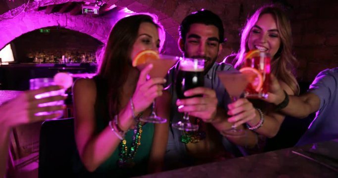 Young multi-ethnic friends celebrating Mardi Gras at New Orleans bar