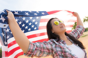 Close up happy woman holding United States of America flag and running carefree with open arms on beach. USA Independence day concept.