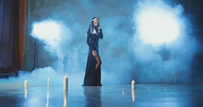 Sexy nun stands exposing her leg in black stockings