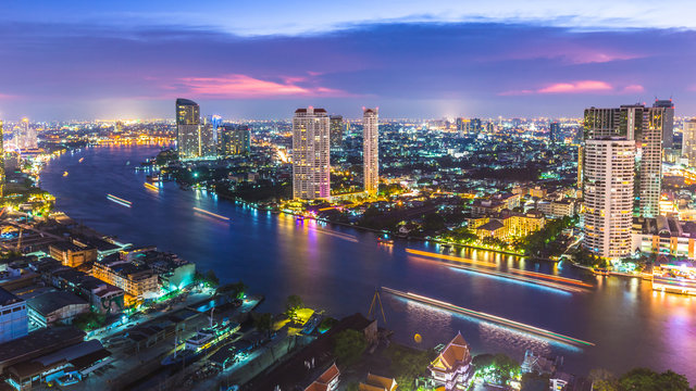 Aerial view of Bangkok City modern office buildings, condominium, hotel in Bangkok city downtown business and finance with Chao Phraya River during sunset sky, Bangkok, Thailand.