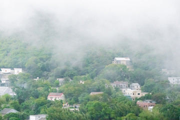 A traditional home on the hillside with fog around in HongKong