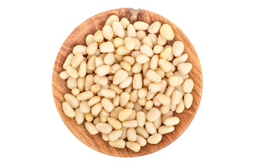 Shelled cedar pine nuts in wooden bowl isolated on white background. Top view. Flat lay