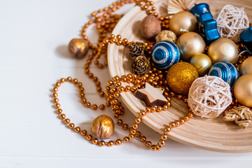 Beads, gold balls. New Year composition.pine cones and Christmas tree decorations on white background. Copy space. Selective focus.