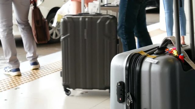 4K footage of passenger with big roller luggage standing on the line waiting for taxi queue at taxi parking lot at airport arrival terminal