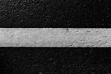 Fototapeta premium dirty white line on surface of old asphalt in countryside