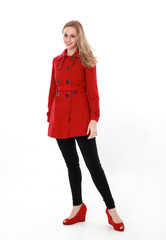 portrait of pretty blonde girl wearing red trench coat, full length standing pose.. isolated on white studio background.