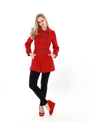 portrait of pretty blonde girl wearing red trench coat, full length standing pose.. isolated on white studio background.