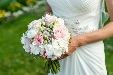 Obraz na płótnie Canvas Wedding bouquet of flowers held by bride closeup. Pink flower