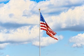 Star-striped American flag flutters proudly against the blue sky.