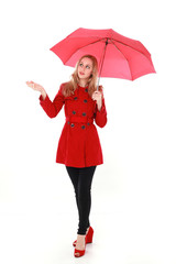 portrait of pretty blonde girl wearing red trench coat, holding an umbrella. full length standing pose. isolated on white studio background.