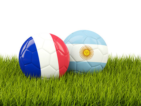 France vs Argentina. Soccer concept. Footballs with flags on green grass