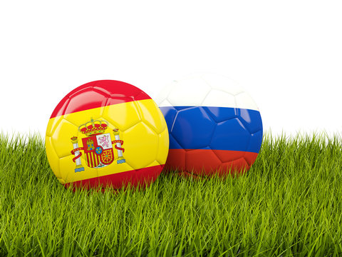 Spain vs Russia. Soccer concept. Footballs with flags on green grass