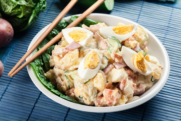 Delicious potato salad with ham, egg and cucumber